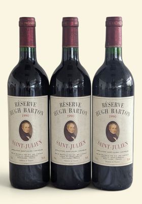 three bottles of red wine sitting on top of a white table