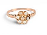 a close up of a gold ring with pearls on it