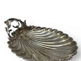 an image of a silver shell shaped dish on a white background
