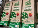 quatre cartons de jus de fruits sont posés sur une étagère dans une épicerie
