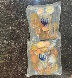 two bags filled with coins sitting on a counter