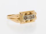a close up of a gold and diamond ring on a white background