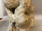 a sculpture of a man holding his head in his hands