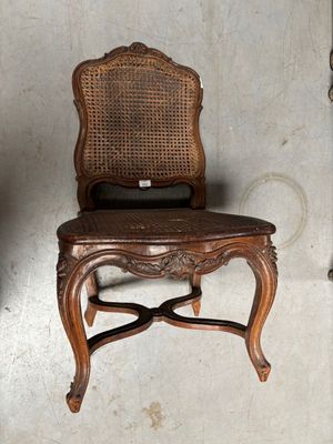 une chaise en bois avec un dossier et une assise en osier