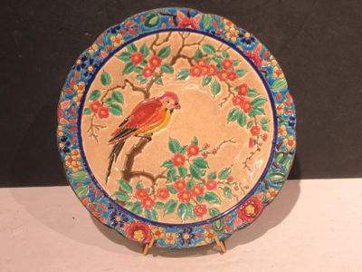 a colorful plate with a bird on it sitting on a table
