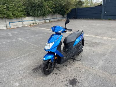 un scooter bleu garé sur un parking