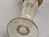 an old fashioned glass bottle with a gold rim on a white surface