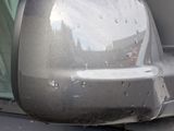 reflection of a car ' s rear view mirror on the side of a car