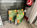 two bags of cat food sitting on the floor