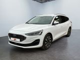 Une voiture blanche est garée dans une pièce blanche au sol noir.