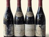 three bottles of red wine are lined up on a table
