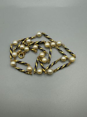 a close up of a necklace with pearls on it