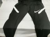 a pair of black pants sitting on top of a bed
