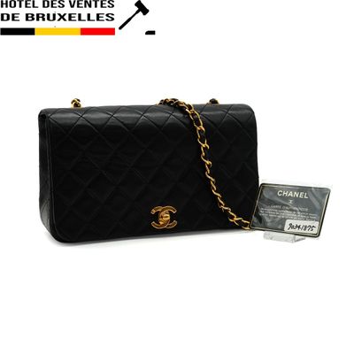 a black chanel bag with a gold chain and a credit card