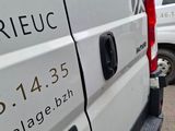 a white van parked in a parking lot with other vans in the background