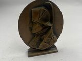 un gros plan sur une statue en bronze représentant un homme coiffé d'un chapeau