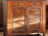 une armoire en bois dans une pièce, sur laquelle est posée une lampe
