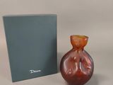 a small glass vase next to a box on a table