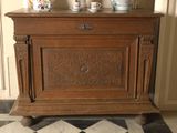 a wooden cabinet with cups on top of it