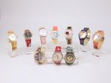 de nombreux modèles de montres exposés sur un présentoir transparent