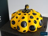 a yellow and black polka dot pumpkin sitting on a black box