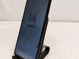 a close up of a cell phone on a stand on a white surface