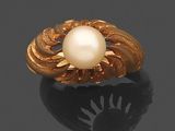 une bague en or sertie d'une perle de culture