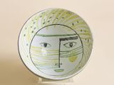 un petit bol sur lequel est dessiné un visage