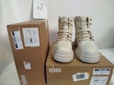 une boîte sur laquelle sont posées deux paires de chaussures blanches