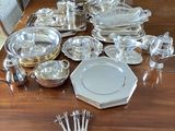 a lot of silver plates and silverware on the table