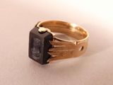an image of a gold ring with a black stone