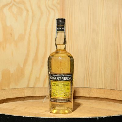 a bottle of liquor sitting on top of a wooden barrel