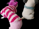 two stuffed animals sitting next to each other on a black background