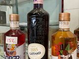 three bottles of alcohol sitting on a counter in front of a glass case