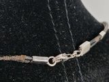 silver plated necklace on a mannequin neck with a clasp