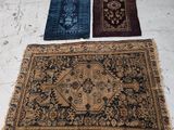 Trois tapis sont disposés sur le sol dans une pièce.