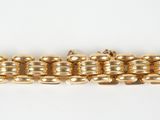 a close up of a gold bracelet on a white surface