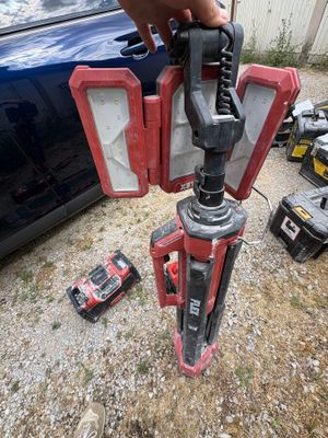 a person holding a tool in their hand next to a car