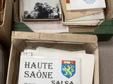Plusieurs cartons remplis de livres sont empilés les uns sur les autres par terre.