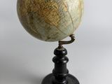 an old globe on a black stand with a white background