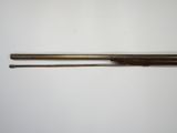 an old gun with a wooden handle on a white surface
