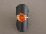 une image d'une bague sertie d'une pierre orange
