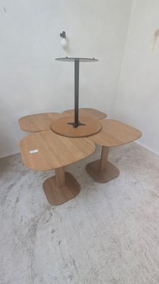 une petite table sur laquelle sont posées trois fleurs, dans une pièce