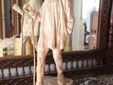 une statue représentant un homme muni d'une canne, posée sur un plan de travail en marbre