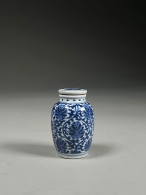 blue and white vase with a lid and a flower design on it