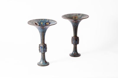 deux vases posés l'un à côté de l'autre sur une surface blanche