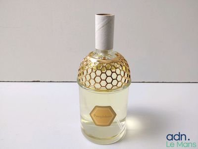 un flacon de parfum posé sur une surface blanche