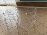 a clear plastic chair and a clear plastic chair in front of a window