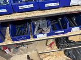 de nombreux bacs bleus contenant des outils, posés sur une étagère dans un garage