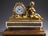 une horloge en or posée sur une table en marbre